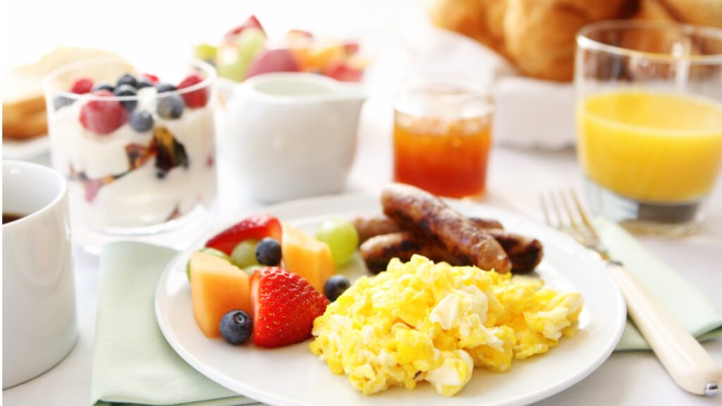 breakfast table with eggs fruit and sausages picture id155370426